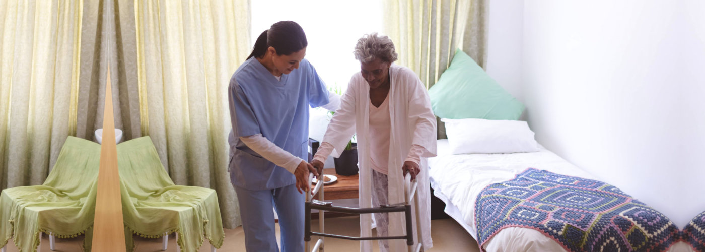 nurse assisting disabled senior woman
